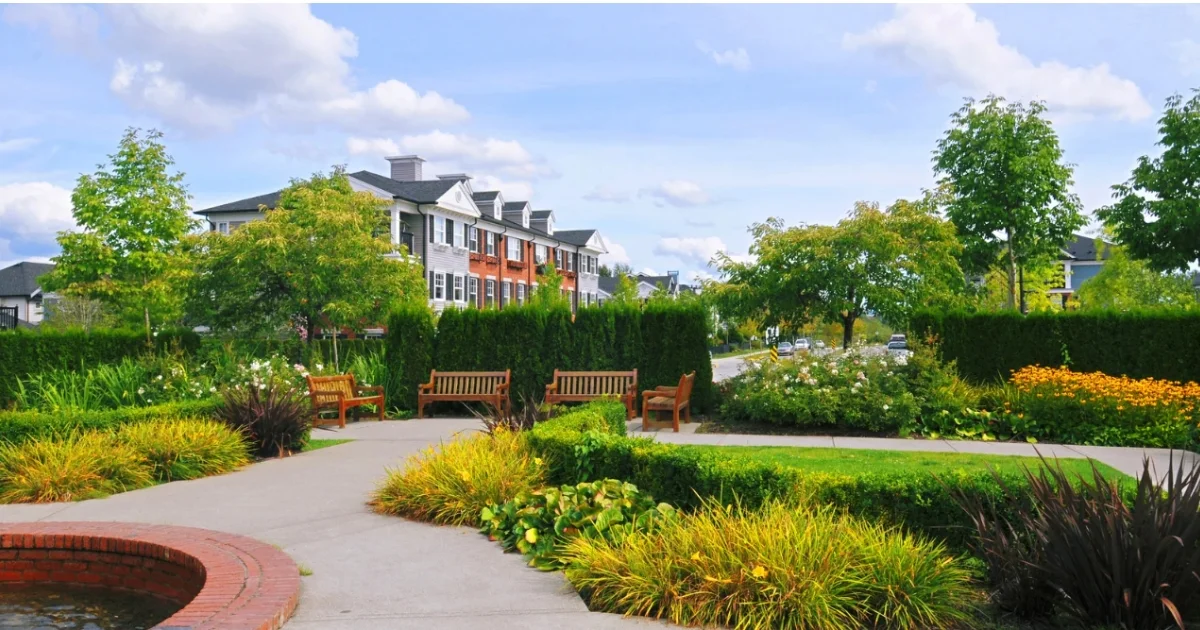 Wooden benches surrounded by landscaped greenery in a community park.
